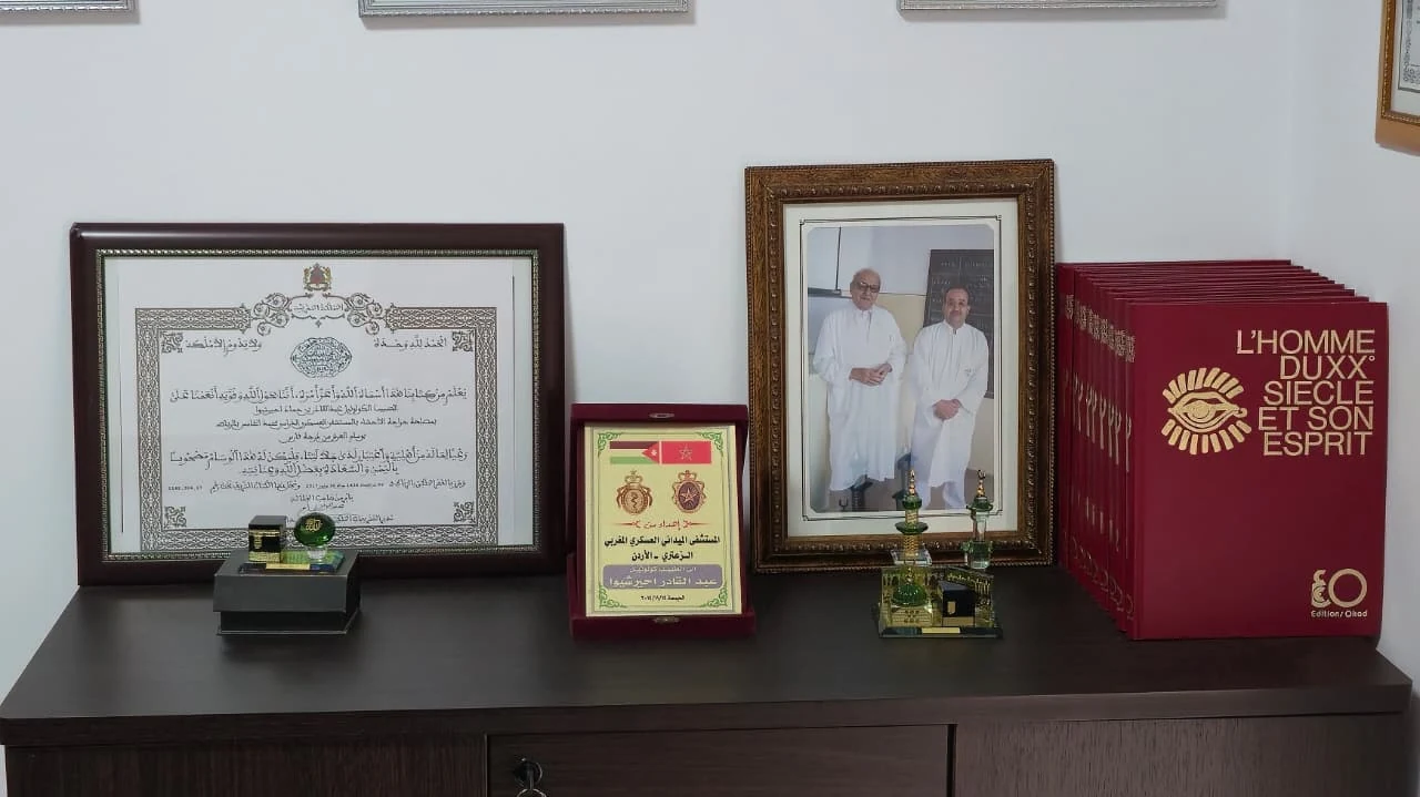 Diplômes, portrait et trophées disposés sur un meuble du cabinet